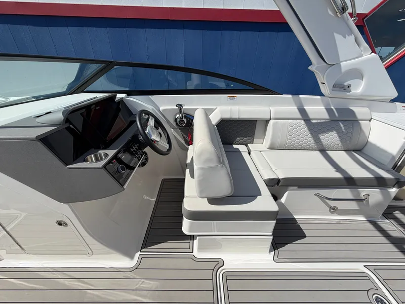 Slide: The Image of The image shows the cockpit of a 2025 Sea Ray SDX 290 with gray upholstery. - 37