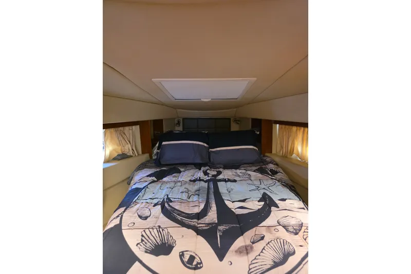 Slide: The Image of Cozy bedroom in 2007 Sea Ray 36 Sedan Bridge with nautical-themed bedding. - 9