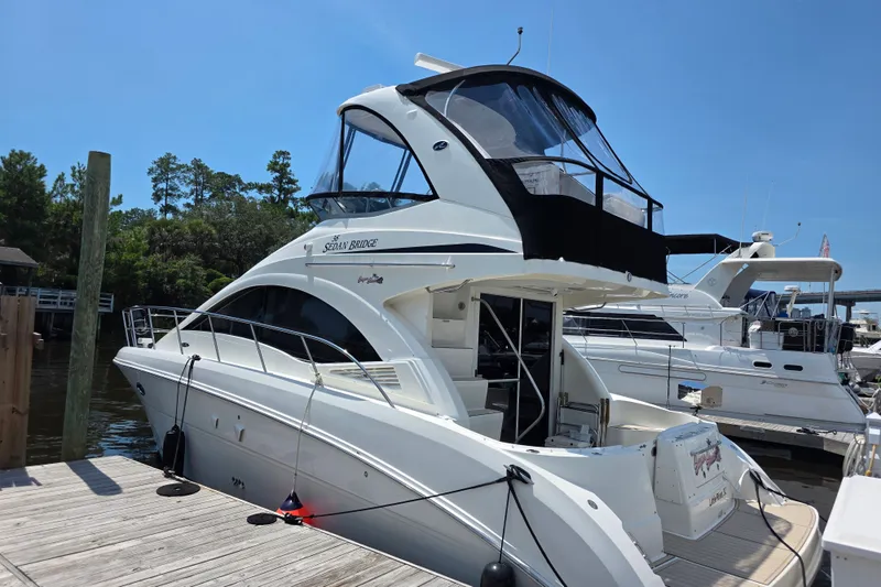 Slide: The Image of 2007 Sea Ray 36 Sedan Bridge yacht docked at marina under clear blue sky. - 3