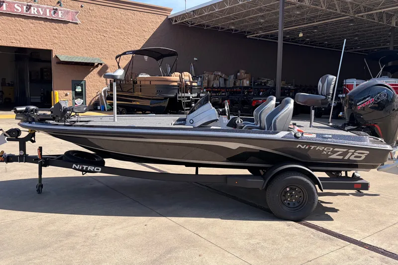 The Image of 2027 Nitro Z18 XL Pro fishing boat on trailer, parked outside service center. - 0