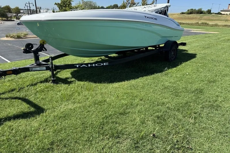 Slide: The Image of 2027 Tahoe T18 boat on trailer, parked on grass in a sunny outdoor setting. - 4