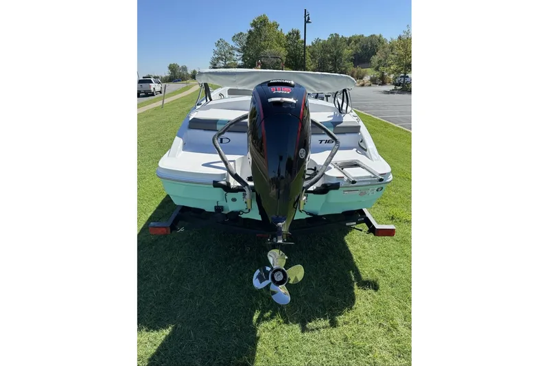Slide: The Image of 2027 Tahoe T18 boat with outboard motor on trailer, parked on grass. - 6