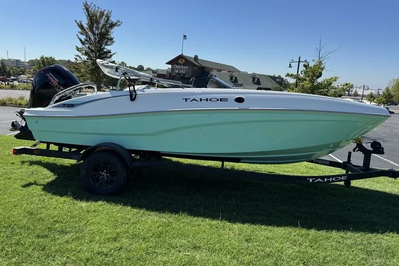 Slide: The Image of 2027 Tahoe T18 boat on trailer, parked on grass, sunny day. - 2