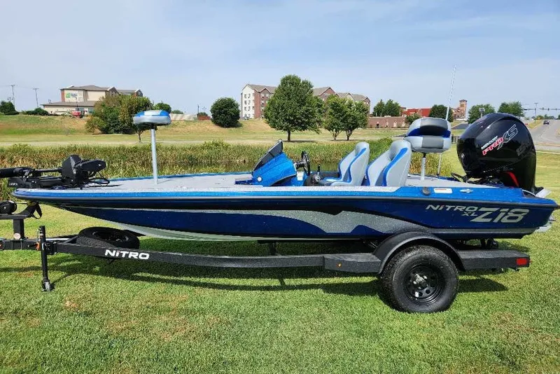 The Image of 2027 Nitro Z18 XL Pro boat on trailer, parked on grass, with blue and white design. - 0