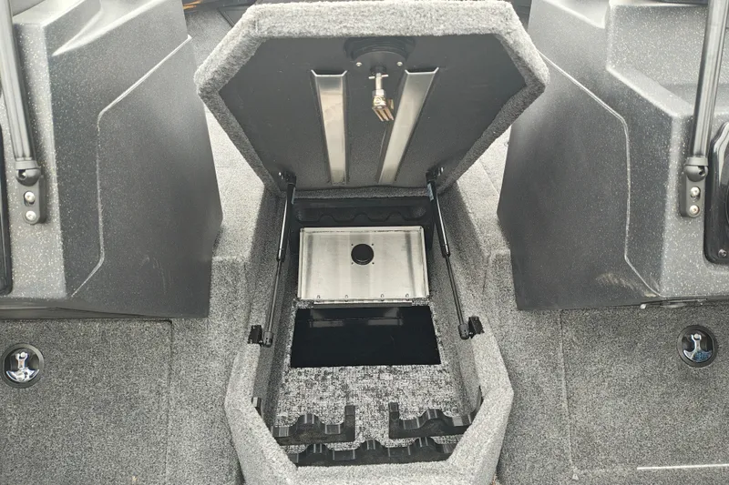 Slide: The Image of 2026 Tracker Targa V-19 WT boat storage compartment with open hatch and carpeted interior. - 28