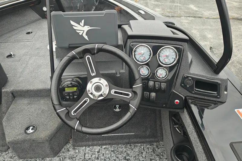 Slide: The Image of 2026 Tracker Targa V-19 WT boat dashboard with steering wheel and gauges. - 14