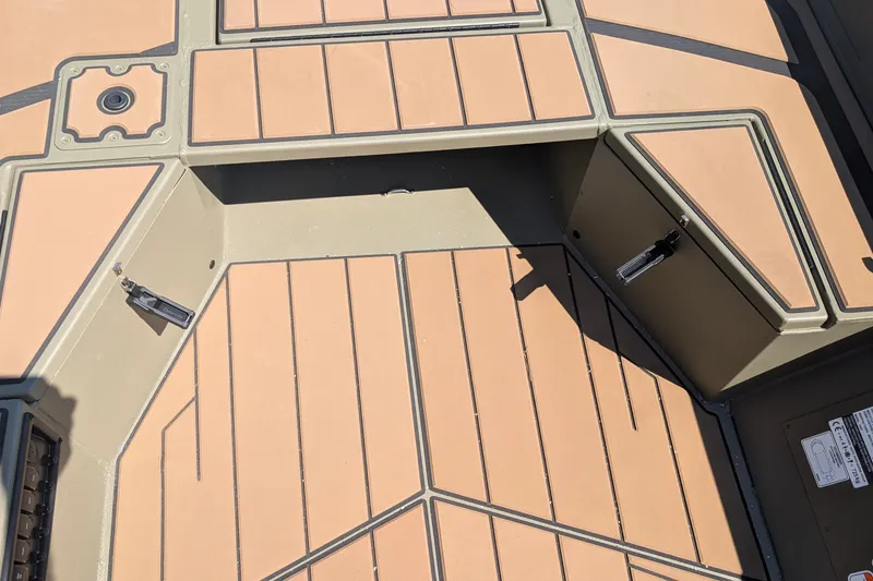 Slide: The Image of Interior view of 2027 Tracker Grizzly 1553 Timber boat deck with tan and black design. - 13