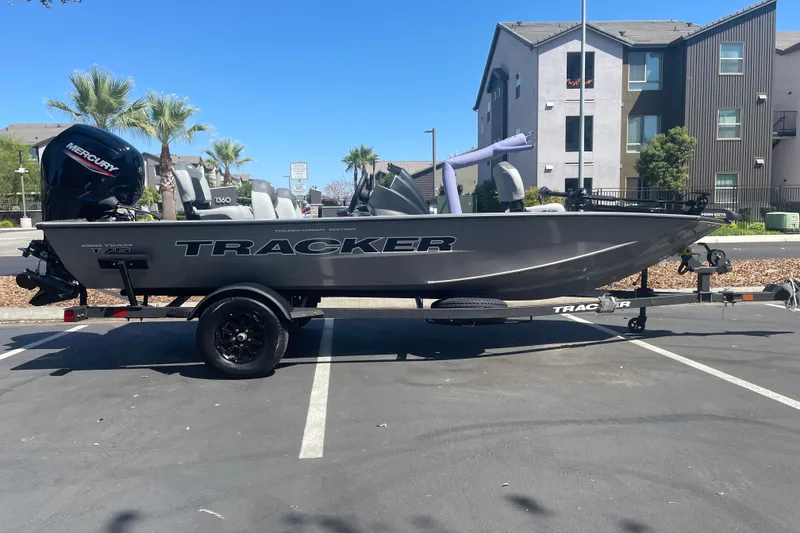 The Image of 2027 Tracker Pro Team 175 boat on trailer in parking lot, sunny day. - 0