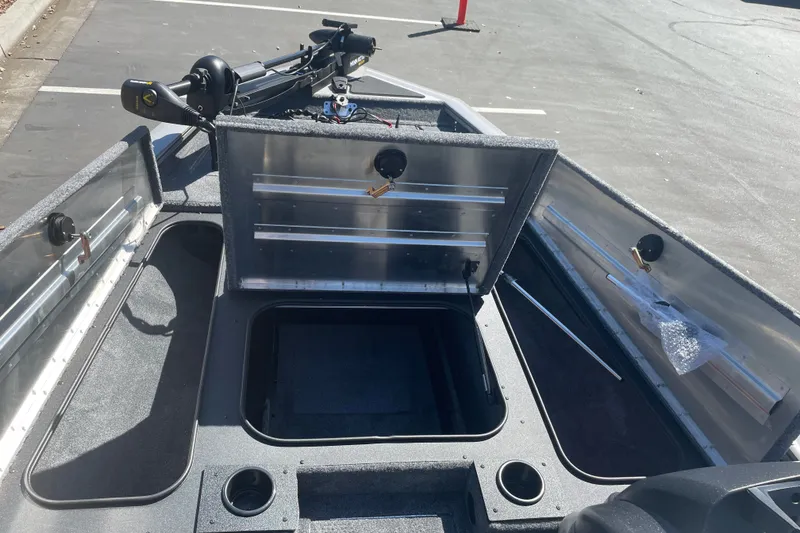 Slide: The Image of 2027 Tracker Pro Team 175 boat interior with open storage compartments and trolling motor. - 13
