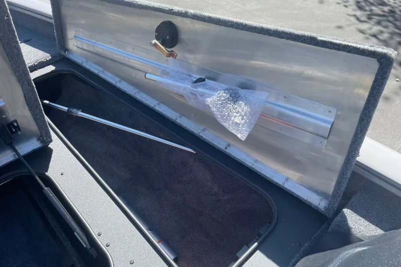Slide: The Image of 2027 Tracker Pro Team 175 boat storage compartment with bubble-wrapped accessory. - 15