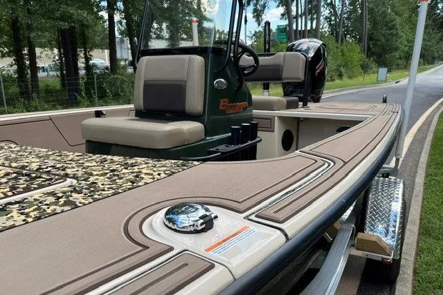 Slide: The Image of 2026 Mako 18 Pro Skiff Backwater Edition boat with camouflage deck, parked on a trailer. - 17