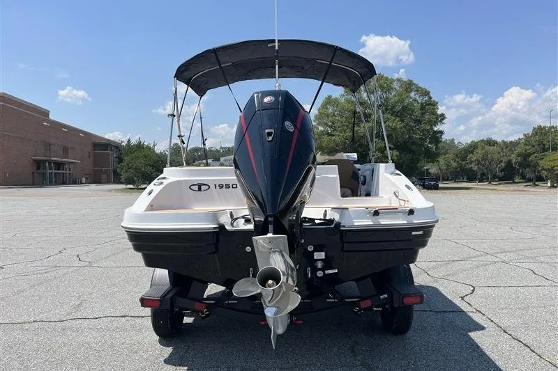 Slide: The Image of 2026 Tahoe 1950 boat with outboard motor, parked outdoors under clear sky. - 4