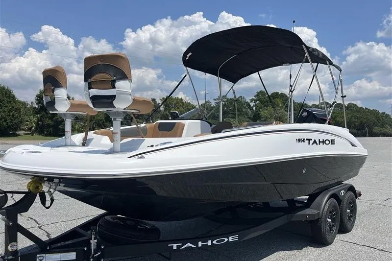 Slide: The Image of 2026 Tahoe 1950 boat on trailer, featuring dual seats and canopy under a clear sky. - 2