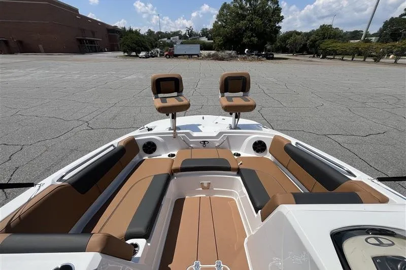 Slide: The Image of 2026 Tahoe 1950 boat interior with tan and black seating in a parking lot. - 12
