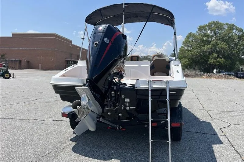 Slide: The Image of 2026 Tahoe 1950 boat with outboard motor and ladder in a parking lot. - 6