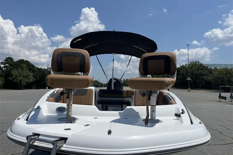 Slide: The Image of 2026 Tahoe 1950 boat with tan seats and canopy under a blue sky. - 7