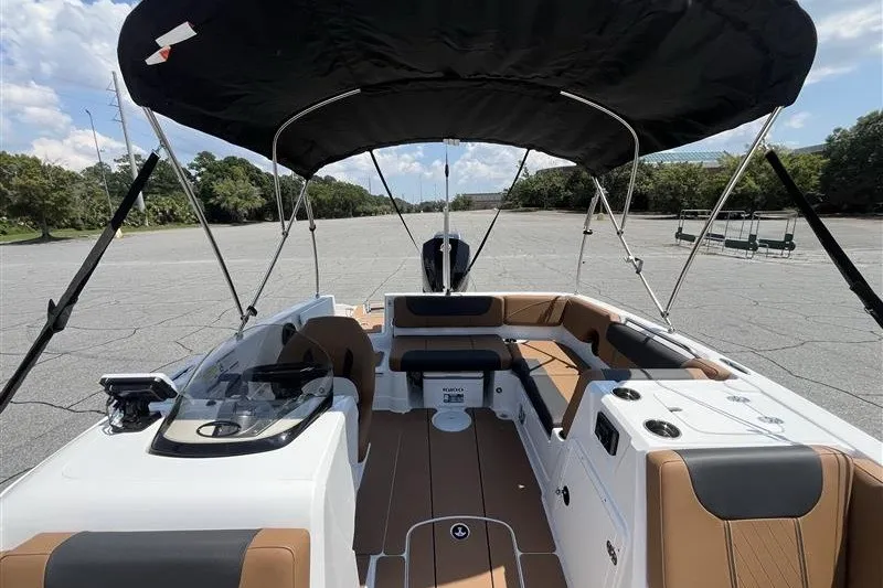Slide: The Image of 2026 Tahoe 1950 boat interior with canopy, featuring brown and white seating. - 11