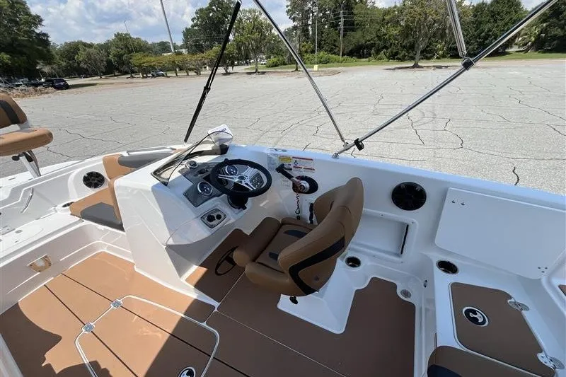 Slide: The Image of Interior of a 2026 Tahoe 1950 boat with brown seating and steering console. - 8