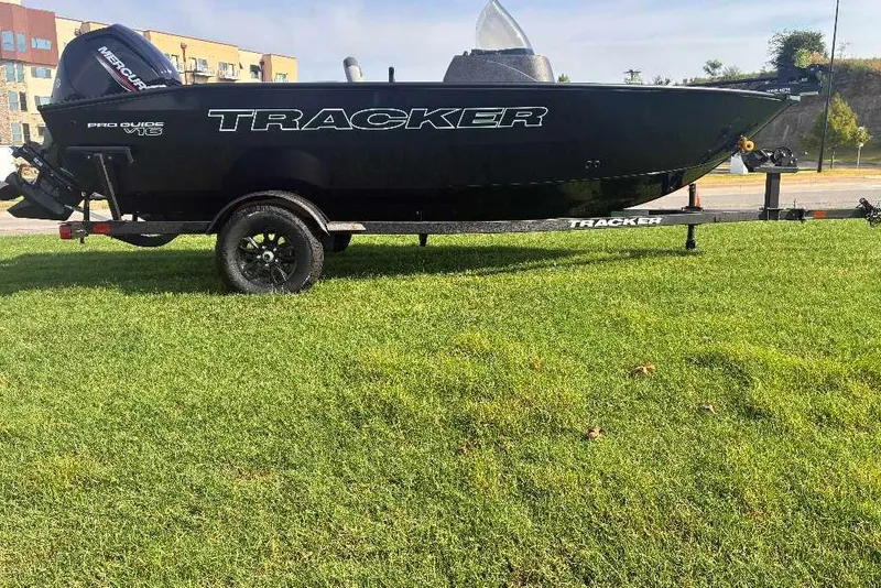 The Image of 2027 Tracker Pro Guide V-16 SC boat on trailer, parked on grass. - 0