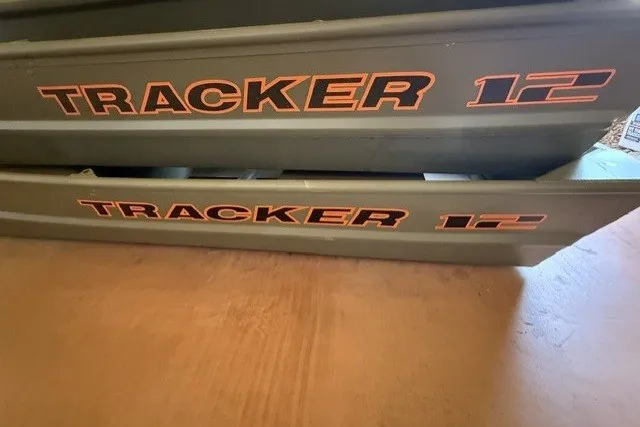 The Image of 2027 Tracker Grizzly 12 Jon boat with bold orange lettering on the side. - 0