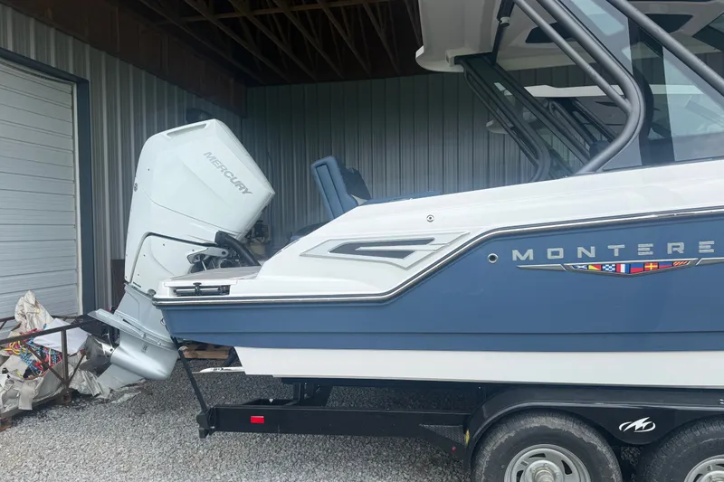 Slide: The Image of 2025 Monterey Elite 27 OB boat with Mercury outboard motor, parked in a garage. - 4