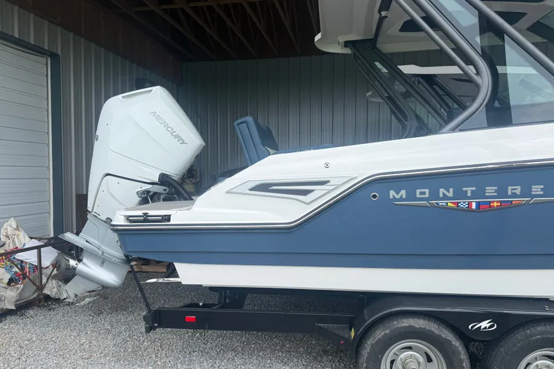 Slide: The Image of 2025 Monterey Elite 27 OB boat with Mercury outboard engine in storage. - 5