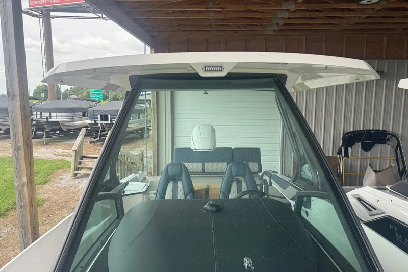 Slide: The Image of 2025 Monterey Elite 27 OB boat with sleek design, docked under shelter. - 12