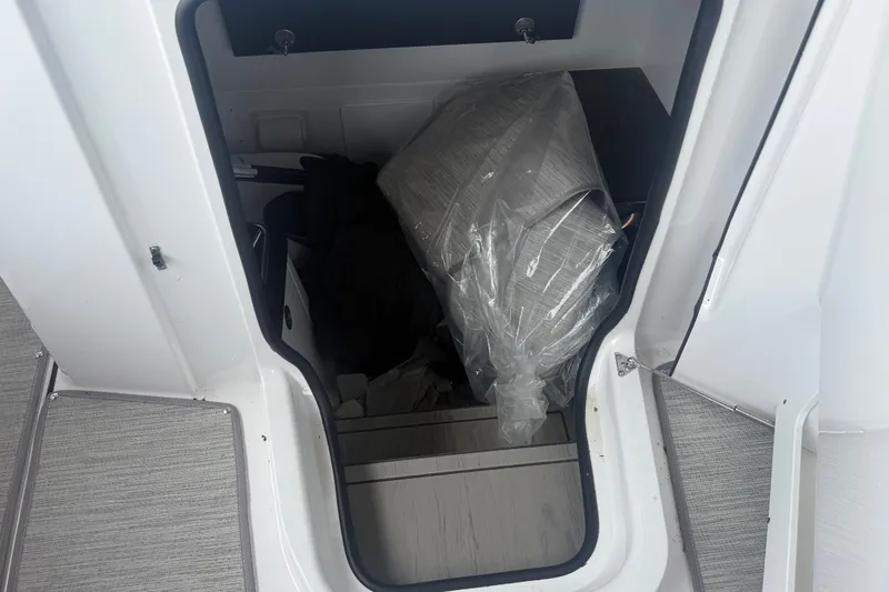 Slide: The Image of Storage compartment of 2025 Monterey Elite 27 OB boat, featuring interior items and packaging. - 11