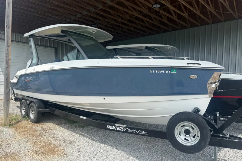 The Image of 2025 Monterey Elite 27 OB boat on trailer, parked in a covered area. - 1