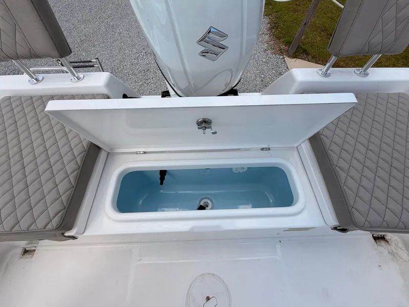 Slide: The Image of The image shows the open storage compartment of a 2027 Savannah 210X boat with cushioned seats. - 15