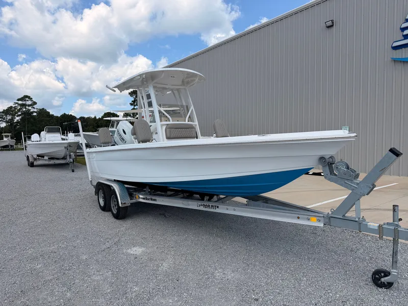 Slide: The Image of A 2027 Savannah 210X boat on a trailer, parked in front of a building. - 7