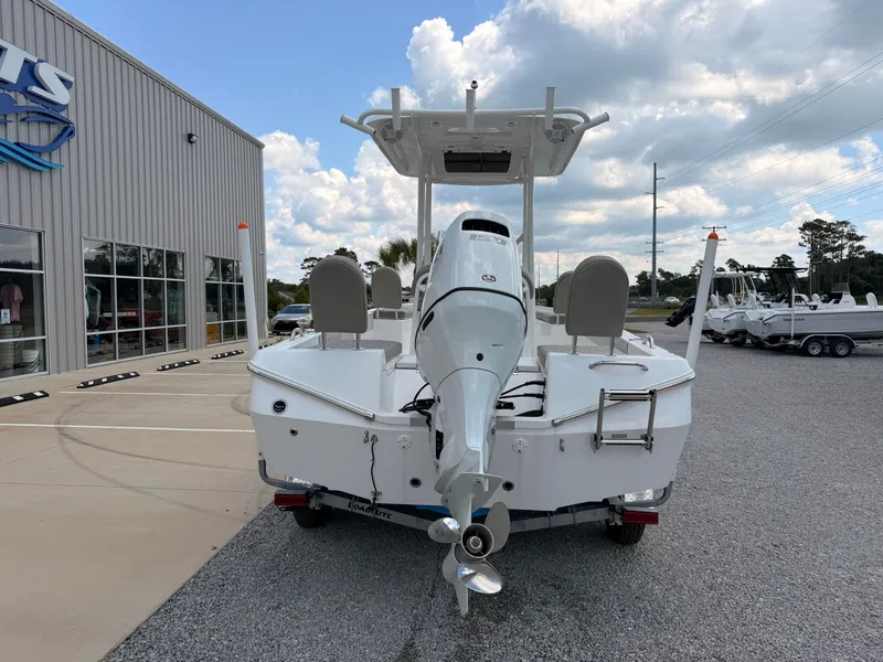 Slide: The Image of A 2027 Savannah 210X boat on a trailer in front of a building. - 2
