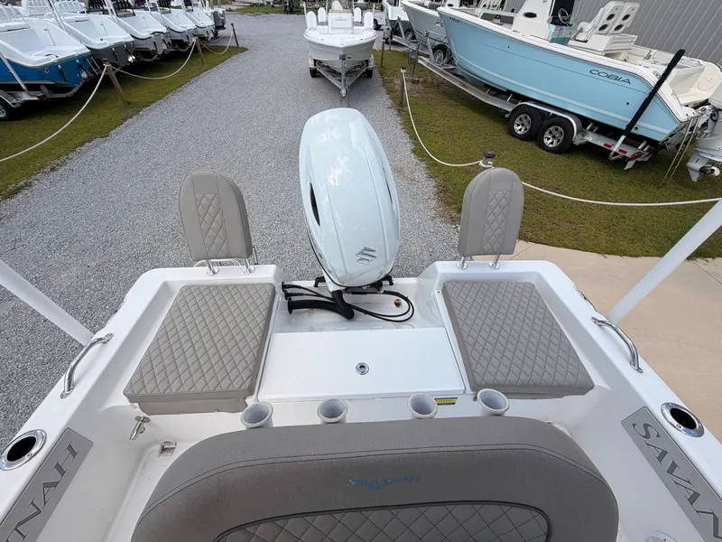 Slide: The Image of The image shows the stern of a 2027 Savannah 210X boat with gray cushions and an outboard motor. - 14
