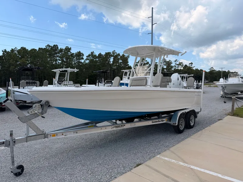 Slide: The Image of A white boat, Savannah 210X model from 2027, sits on a trailer in a parking area. - 5