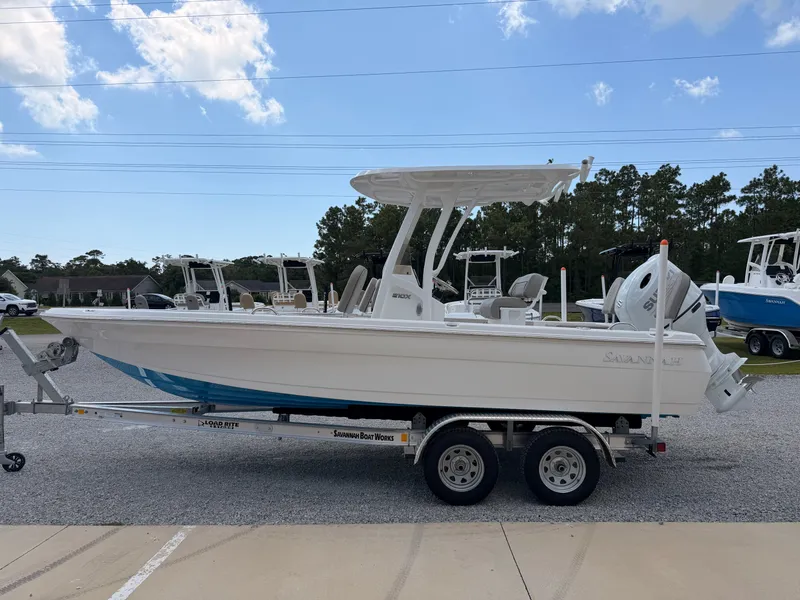 Slide: The Image of A 2027 Savannah 210X boat on a trailer, surrounded by other boats and trees. - 4