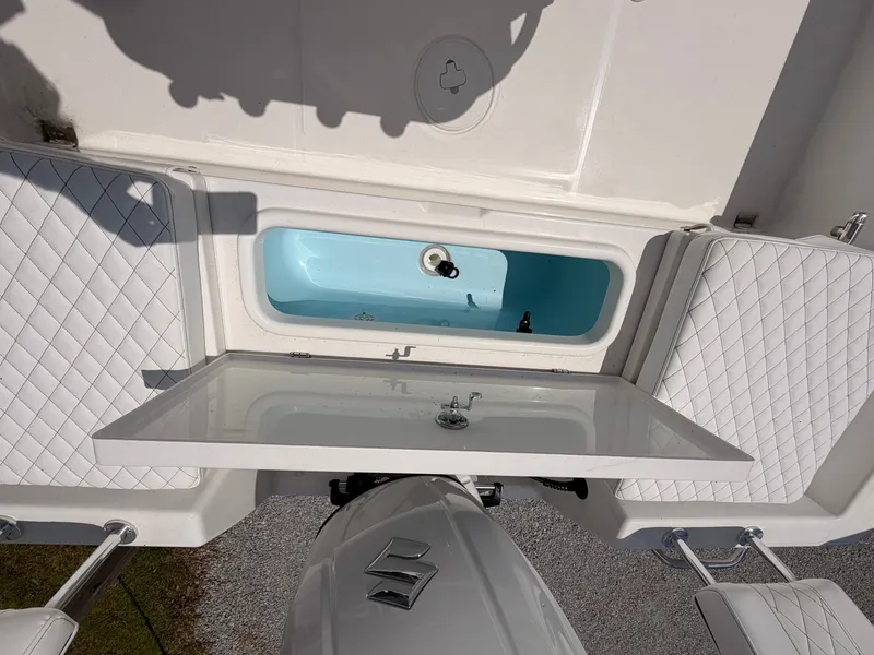 Slide: The Image of The image shows the stern of a Savannah 210X boat with a Suzuki outboard motor and a blue storage compartment. - 14