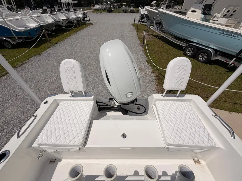 Slide: The Image of The image shows the stern of a Savannah 210X boat with an outboard motor and white seats. - 13