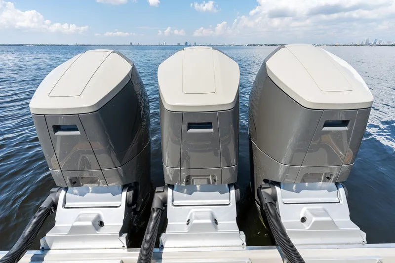 Slide: The Image of Triple outboard motors on a 2023 HCB 42 Lujo boat, cruising on open water. - 25