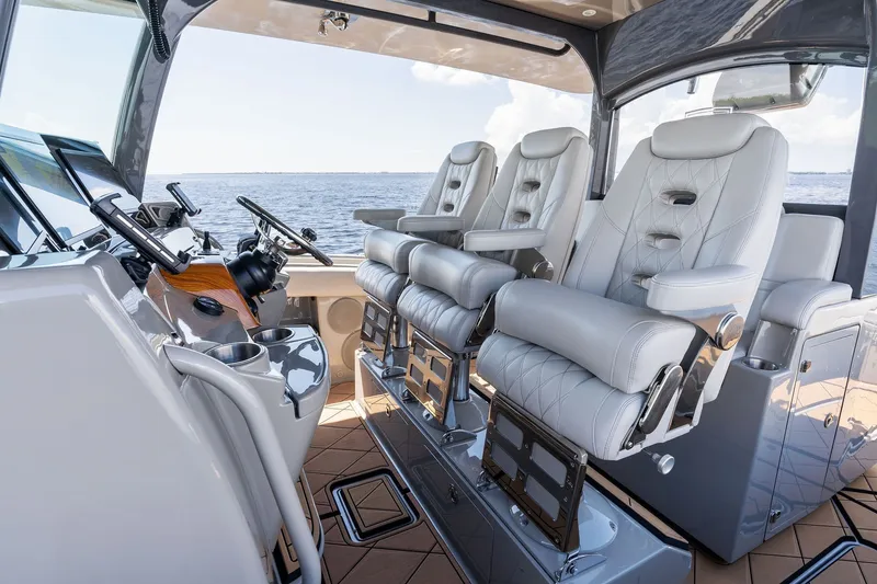 Slide: The Image of Luxurious helm seating on 2023 HCB 42 Lujo boat, featuring modern controls and ocean view. - 49