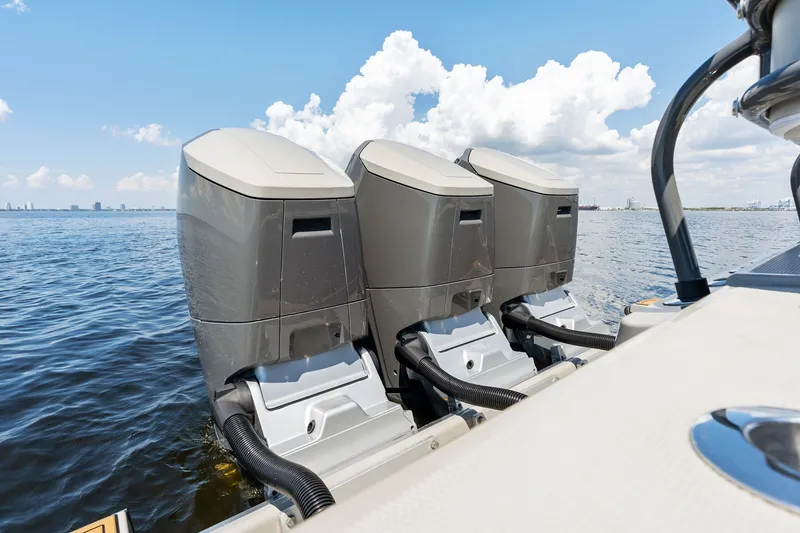 Slide: The Image of Triple outboard engines on a 2023 HCB 42 Lujo boat, cruising on open water. - 26