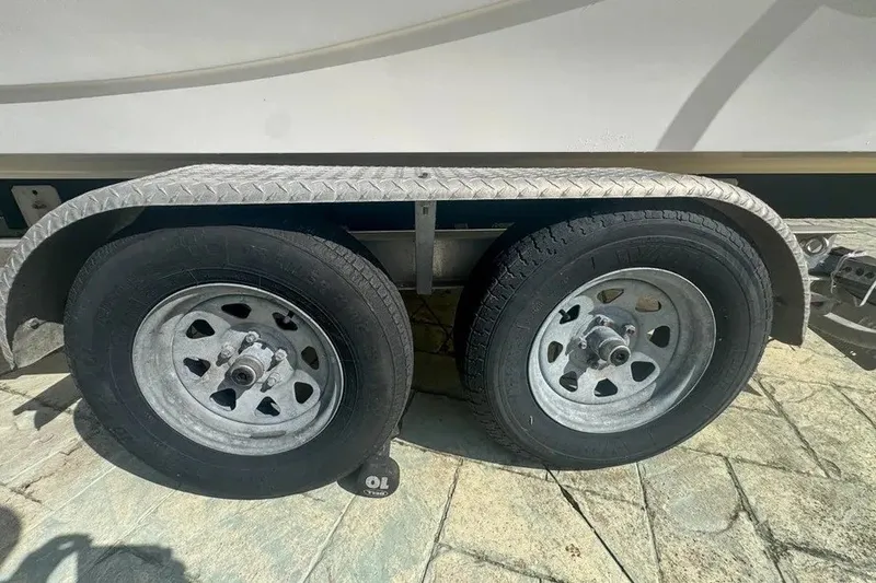 Slide: The Image of Trailer wheels of a 2018 Blue Wave 2400 PureBay boat on a sunny day. - 77