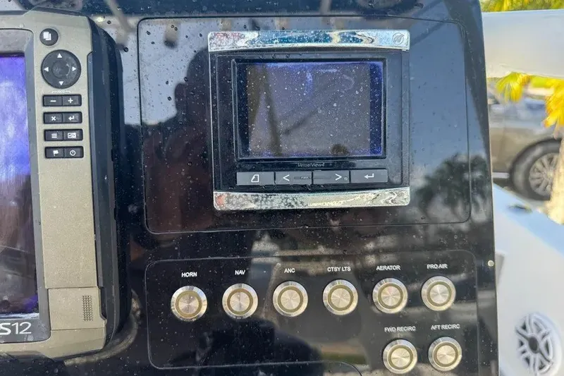 Slide: The Image of Control panel of a 2018 Blue Wave 2400 PureBay boat with various buttons and screens. - 45
