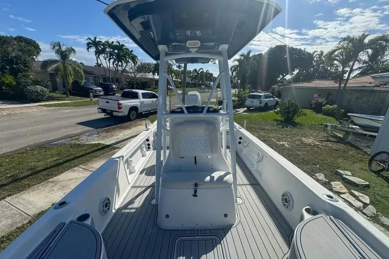 Slide: The Image of 2018 Blue Wave 2400 PureBay boat with center console, parked in a residential area. - 37