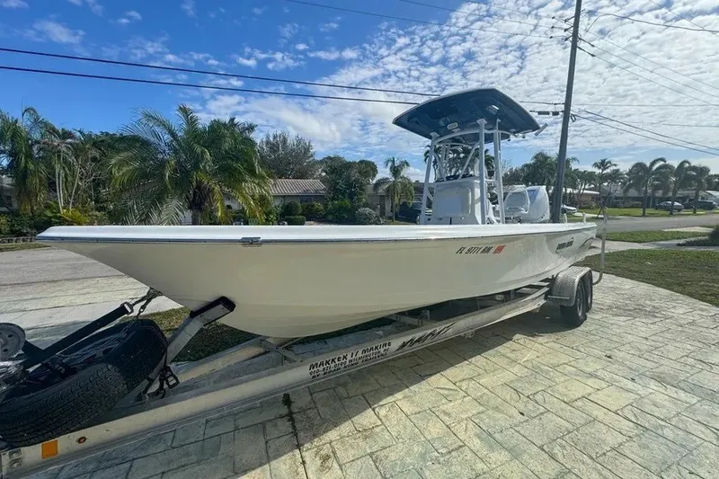 Slide: The Image of 2018 Blue Wave 2400 PureBay boat on trailer, parked in a sunny residential area. - 2