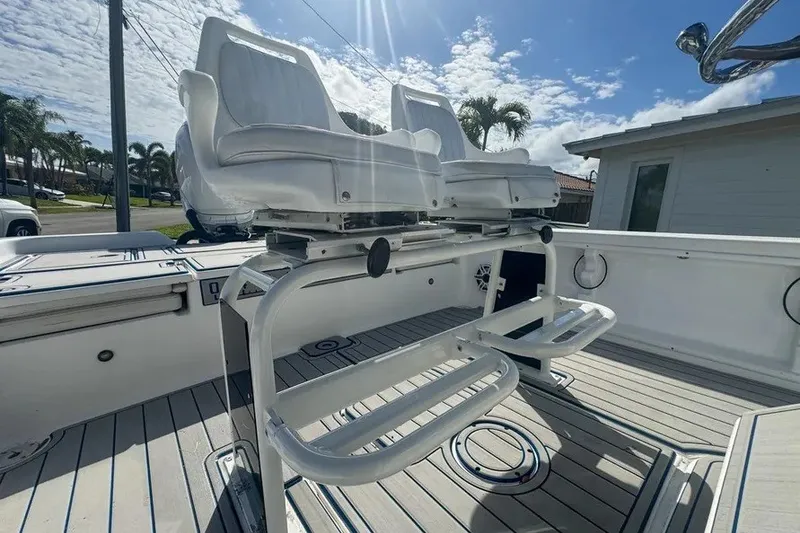 Slide: The Image of 2018 Blue Wave 2400 PureBay boat interior with dual white seats and sunny sky. - 59