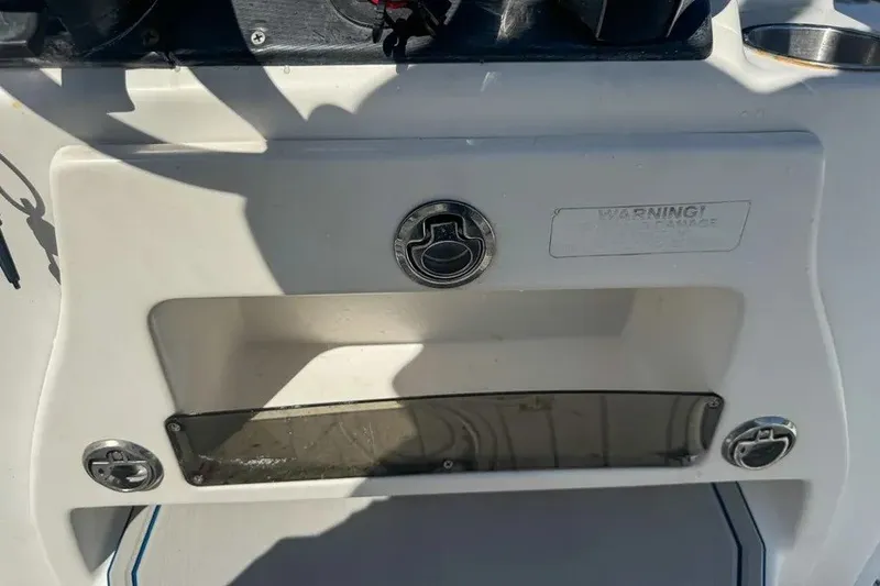 Slide: The Image of 2018 Blue Wave 2400 PureBay boat dashboard with storage compartment and warning label. - 46