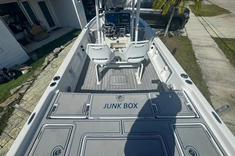 Slide: The Image of 2018 Blue Wave 2400 PureBay boat interior with "Junk Box" storage, docked outdoors. - 11