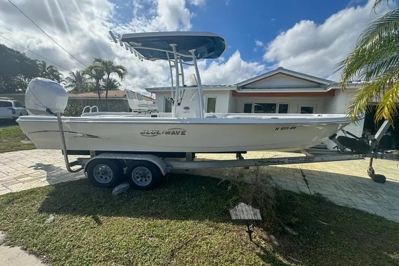 Slide: The Image of 2018 Blue Wave 2400 PureBay boat on trailer, parked in front of a house. - 4