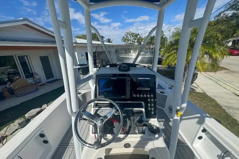 Slide: The Image of 2018 Blue Wave 2400 PureBay boat cockpit with steering wheel and navigation equipment. - 22