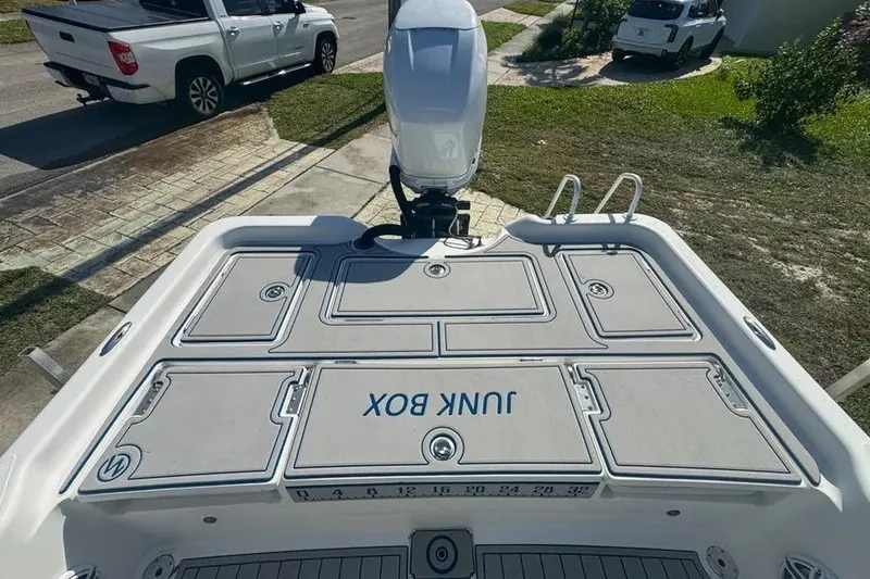 Slide: The Image of 2018 Blue Wave 2400 PureBay boat with outboard motor and deck storage compartments. - 51